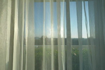 sunlight in morning day through white curtain on window