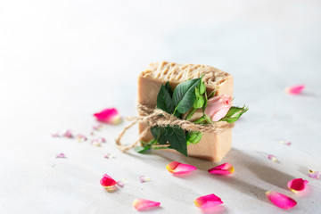 Organic handmade soap, pink rose bud on a white concrete background. Natural and non-waste cosmetic ingredients. Healthy lifestyle concept.