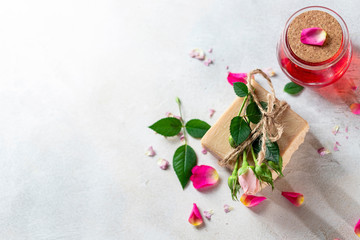 Obraz na płótnie Canvas Organic handmade soap, pink rose bud on a white concrete background. Natural and non-waste cosmetic ingredients. Healthy lifestyle concept.