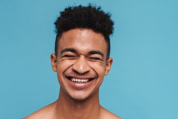 Photo of joyful african american man laughing with eyes closed