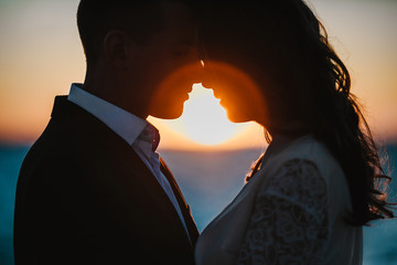 Portrait of a Romantic couple on the sunset with closed eyes by the sea