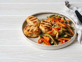 Turkey cutlets grill, vegetables steer fry on a plate on wood board table.
