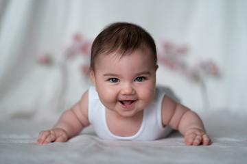 Beautiful baby girl with a white background crawling and smiling