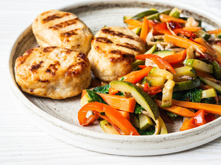 Turkey cutlets grill, vegetables steer fry on a plate on wood board table.