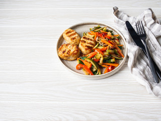 Turkey cutlets grill, vegetables steer fry on a plate on wood board table.