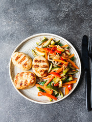 Turkey cutlets grill, vegetables steer fry on a plate on the table on dark background. Top view