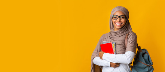 Portrait of black girl student in headscarf with backpack and notepads