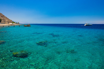 Red sea landscape summer time Israeli scenic view coral reefs beach relaxation people on a pier and yacht on water surface in sunny weather bright day beautiful destination for vacation season