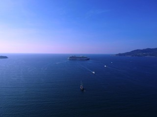 Panoramic View of Patong Beach buildings boats parasailing jetski people on the beach and beautiful blue skies long tail boats