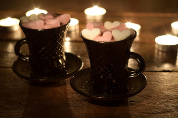 two cups of coffee with marshmallow hearts