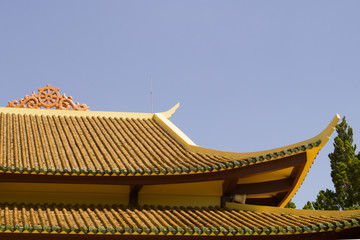 Naklejka premium roof of a buddhist temple against the sky on a sunny day