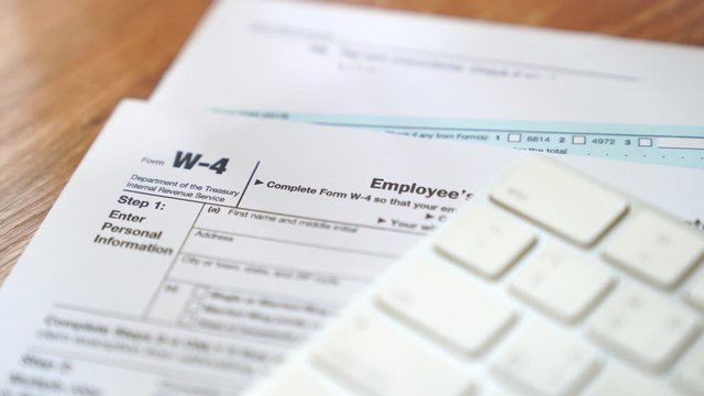Tax form and keyboard computer on the desk.