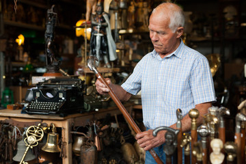 Elderly man chooses rare walking stick at street market