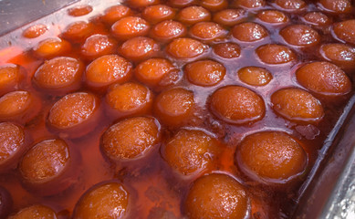 Indian sweet Gulab Jamun in cardamom flavoured sugar syrup background