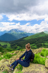 Fototapeta na wymiar a tourist is walking along a mountain path. panorama of the Alpine mountains . mountain tourism. a trail for a walking route. Caucasian mountains. summer landscape with mountains.