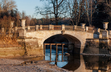 Old bridge with stone vases in Pavlovsk Park on a clear autumn frosty evening