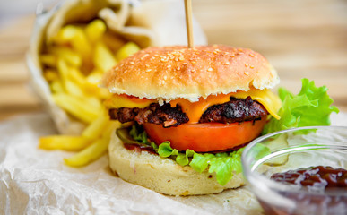 burger and french fries on wooden table. fast food