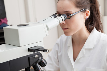 Laboratory assistant uses a polarizing microscope in a microbiological laboratory