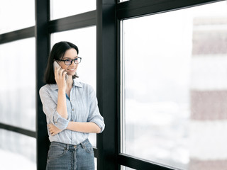 European girl talking on cell phone at office
