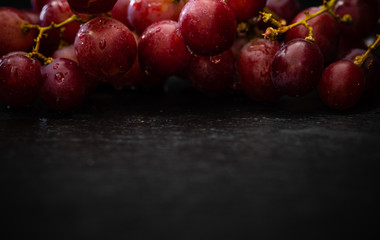 red grapes with drops of water on black background - dark food photography