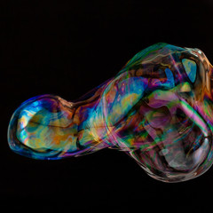 Colorful creative amorphous soap bubble floating with a black background