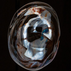 Colorful creative amorphous soap bubble floating with a black background