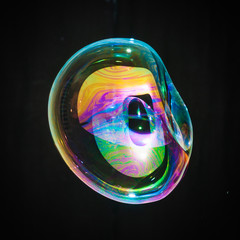 Colorful creative sphere soap bubble floating with a black background