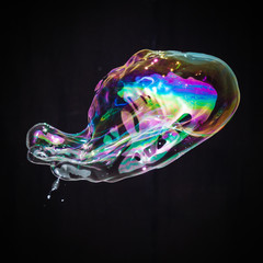 Colorful creative amorphous soap bubble floating with a black background
