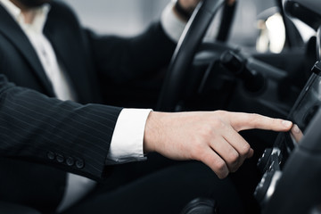 Handsome caucasian businessman driver inside in vehicle  with coffee and gadget and check mail and talking with partners
