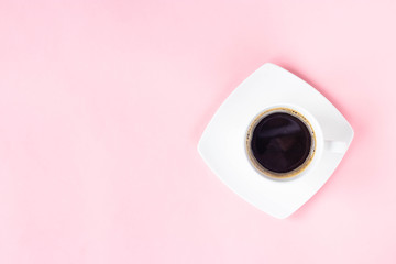 Cup of freshly ground coffee on pink background.
