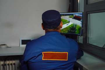 security guard sits at the MONITOR of the CCTV camera.