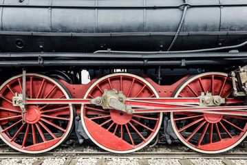 Three red big wheels on an old steam locomotive