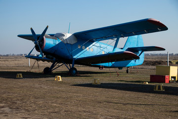 Fototapeta na wymiar Old airplanes. Green and blue corncob. Sports plane of the 19th century. Until now they fly. Touch the antiquity. Propeller and wings. Airplane repair. Aerodrome. Blue sky. Sunny.