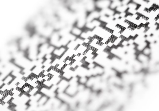 Fragment Quick Response Code on paper close up. Abstract background with blur.