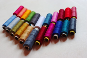 colorful spools of sewing thread on a white background