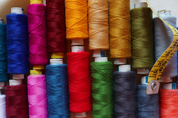 colorful spools of sewing thread on a white background