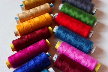 colorful spools of sewing thread on a white background