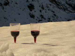 glass of red wine on the snow