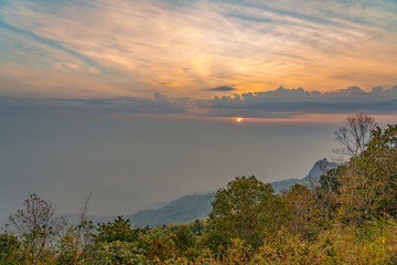 Beautiful views and landscapes surrounded by mountains where the sun is setting and covered with clouds and faded fog.