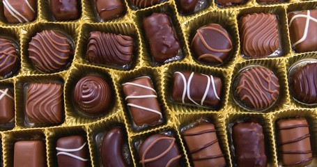 Selection of pralines with milk and dark chocolate in box. Loving chocolate and sweets concept. Dolly shot 4k - Powered by Adobe