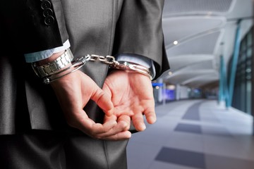 Male hands in handcuffs behind his back