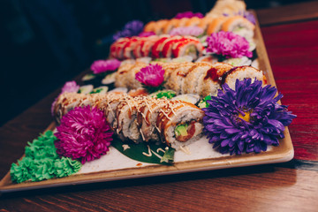 A large set of Delicious sushi rolls view from above Flat Lay . A lot assortment Philadelphia roll Dishes from Japanese raw fish  in one plate in traditional restaurant. Copy Space Japan menu service