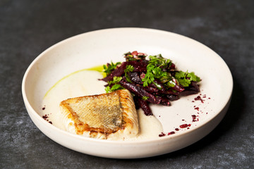 Fried fish perch with vegetables on a white table on grey table
