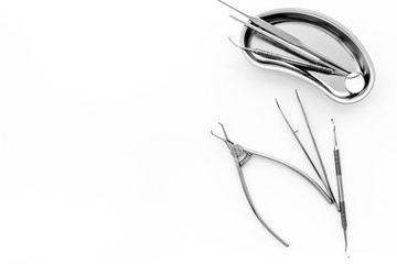 Naklejka premium Stomatological tools in tray on dentist's desk on white background top-down frame copy space