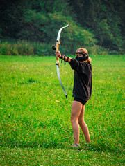 Blonde teenage girl playing archery tag 
