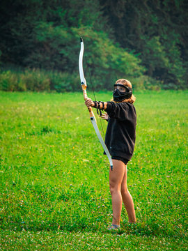 Blonde teenage girl playing archery tag 