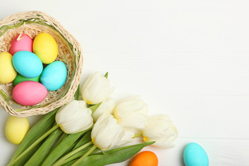 Easter eggs and flowers on the table top view. Easter composition with a place to insert text.