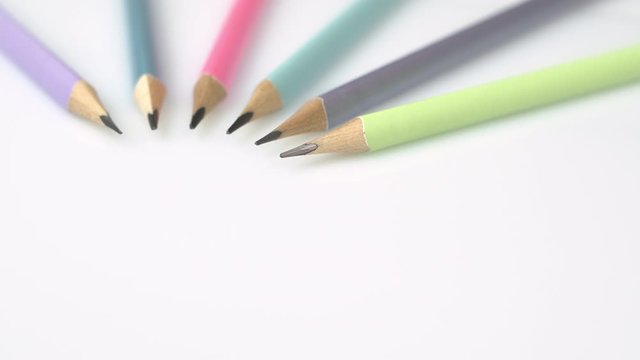 Rotate dolly shot of a group of coloured new pencils on a white background. Shot in 6k.