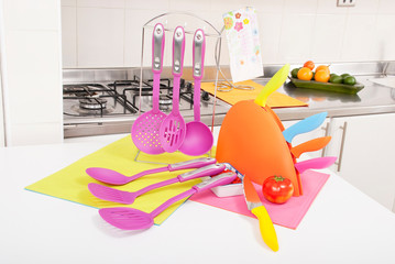Kitchen tools; set of plastic ladles and knives colorful.
