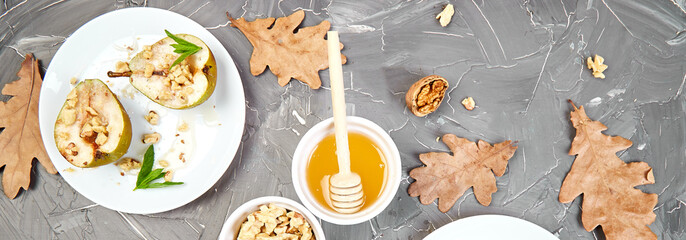 Banner of Tasty roast pears with honey and walnuts on grey background table.
